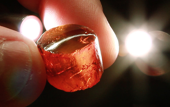 two fingers holding a piece of amber
